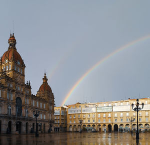 Rainbow over buildings in city