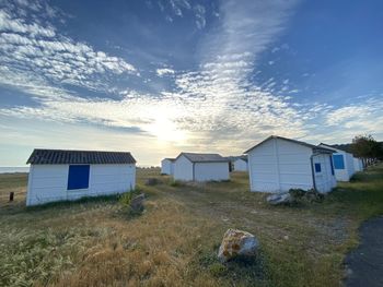 Houses on field against sky