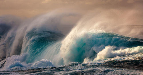 Water splashing in sea against sky