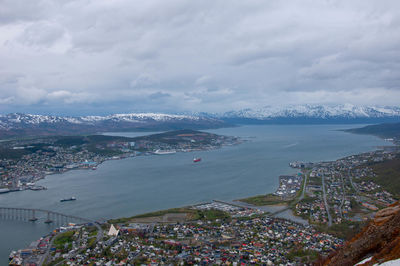 High angle view of city by sea against sky