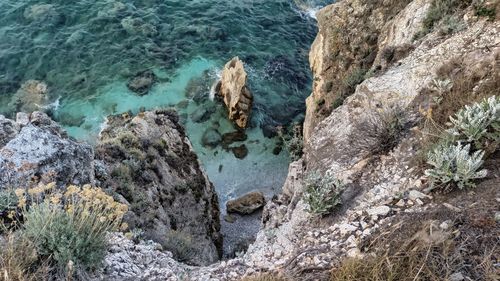 High angle view of rocks on sea shore