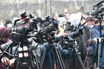 Close-up of cameras with crowd in background