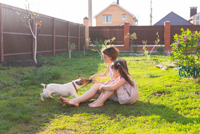 Woman with dog sitting on grass