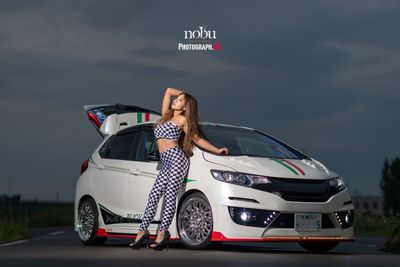 Woman standing on car against sky