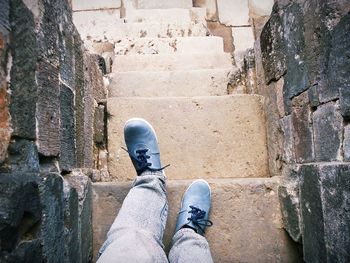 Low section of man wearing shoes on wall