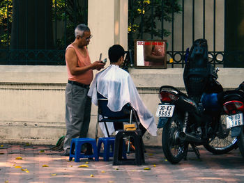 People sitting on street in city