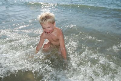 Full length of shirtless boy in sea