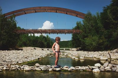 Man standing on rock by lake