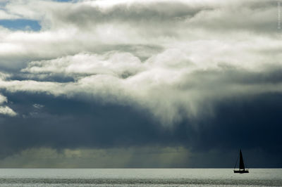 Scenic view of sea against storm clouds