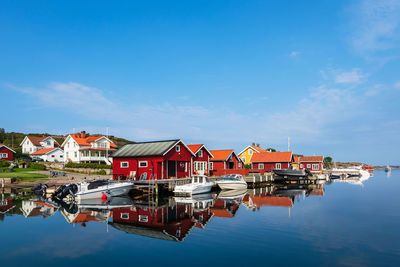 Reflection of buildings in lake against blue sky