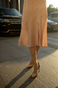 Low section of woman standing on road