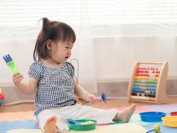 Baby girl playing with toys at home