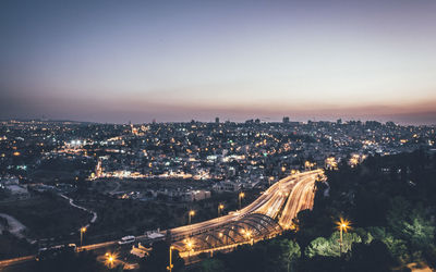 High angle view of illuminated cityscape against sky at night