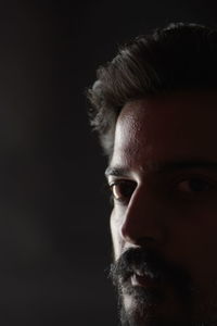 Portrait of young man against black background