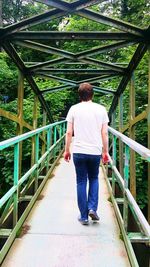 Rear view of woman standing on footbridge