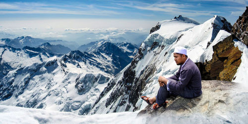 Man sitting on snowcapped mountain