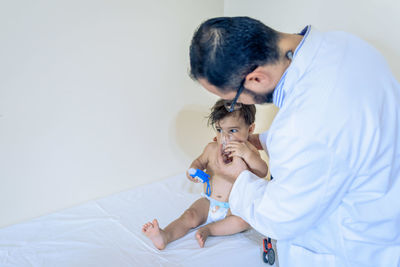 Doctor observing a one-year-old baby