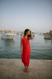 Woman standing on sea shore against sky