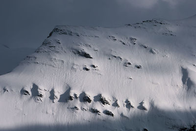 Aerial view of snow covered land against sky