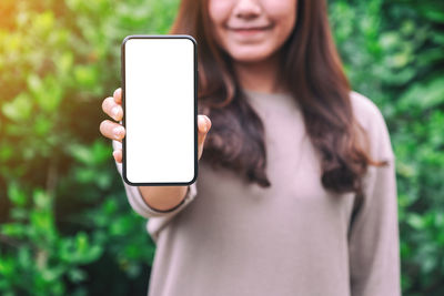 Midsection of woman using mobile phone