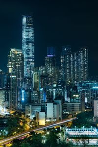 Illuminated buildings in city against sky at night