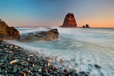 Scenic view of rocks in sea against sky