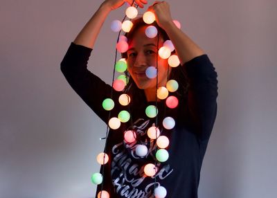 Midsection of woman standing against illuminated wall