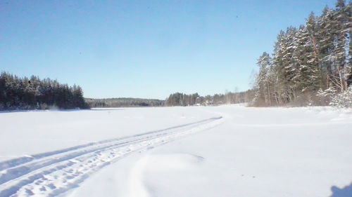 Snow covered landscape against clear sky