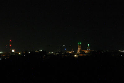 Illuminated cityscape against sky at night