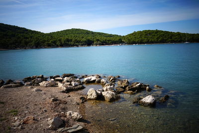 Scenic view of rocks by lake against sky