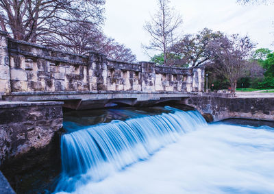 Scenic view of waterfall against sky