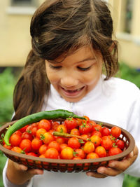 Cute girl holding fruits in plate homegrown tomatoes