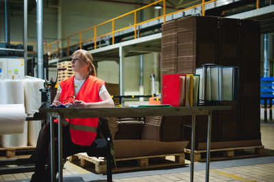 Woman in reflective clothing working at factory