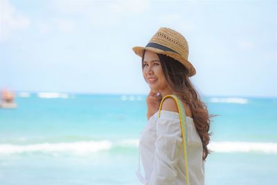 Portrait of woman standing by sea against sky