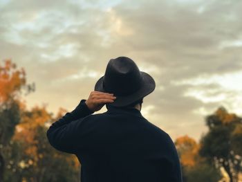 Rear view of silhouette man standing against sky