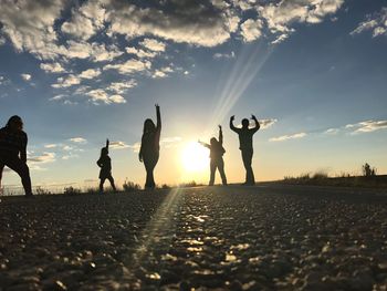 Silhouette people standing against sky during sunset