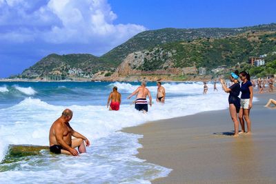 Men on beach against sky