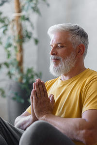 Mature man meditating at home