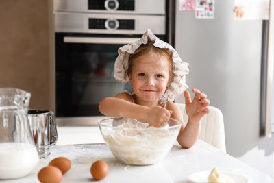 Little girl cooking pizza in the kitchen