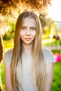 Portrait of a pretty long-haired teenager's face in the atmospheric illumination of sun