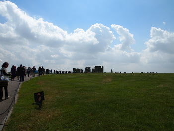 Group of people on field against sky