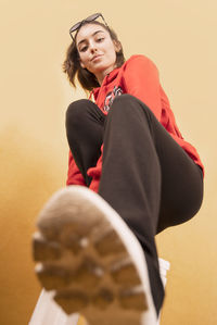 Portrait of smiling woman standing against wall