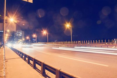 Illuminated road against sky at night during winter