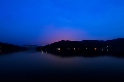 Scenic view of lake against sky at night