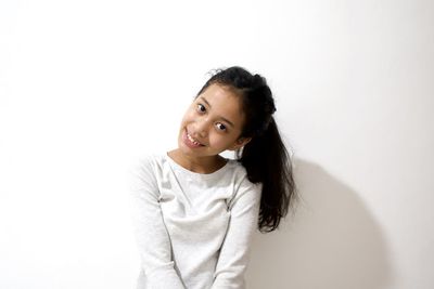 Portrait of girl standing against white background