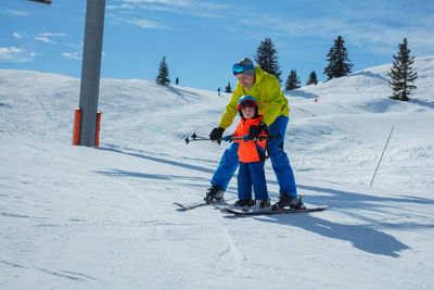 Low angle view of woman skiing on snow covered landscape