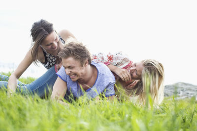 Playful young friends piling on each other at field