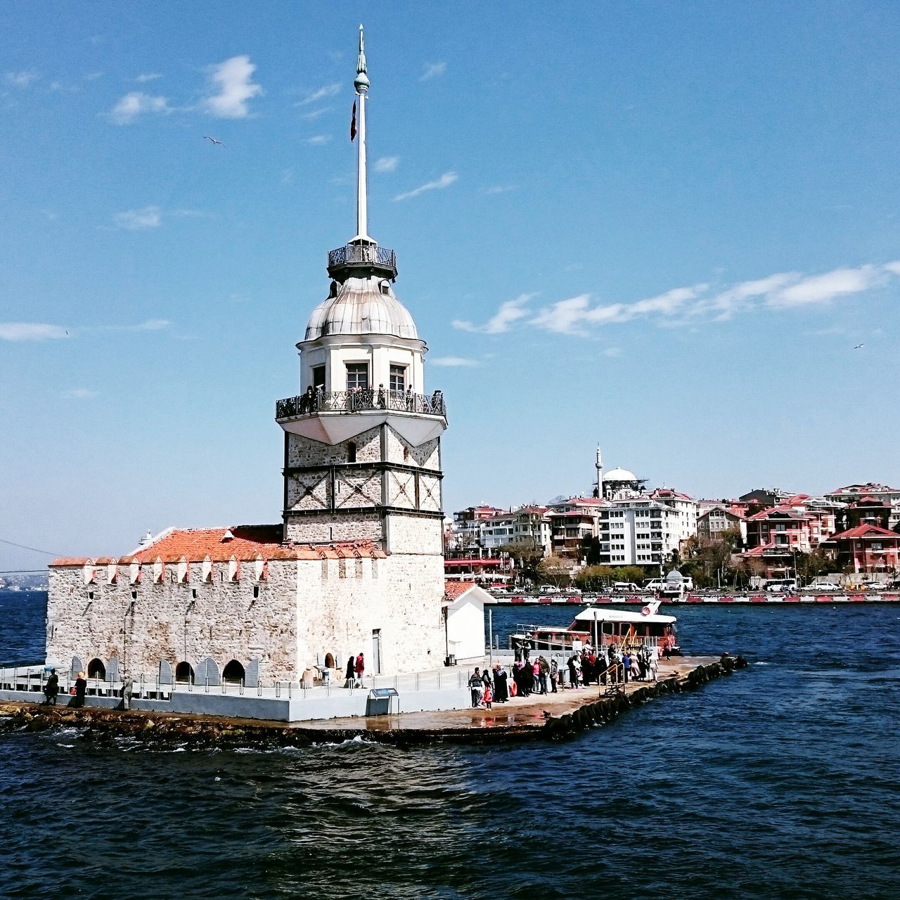 building exterior, water, architecture, built structure, sea, waterfront, lighthouse, sky, guidance, blue, rippled, tower, nautical vessel, day, direction, cloud - sky, transportation, cloud, outdoors, nature