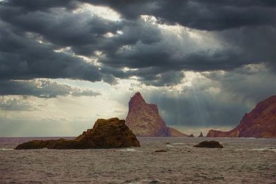 Rock formations in sea against sky