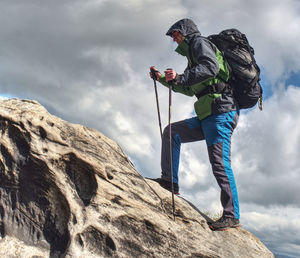 Climbing high up. mountaineer with backpack hiking in mountains, climbing lifestyle. man on top